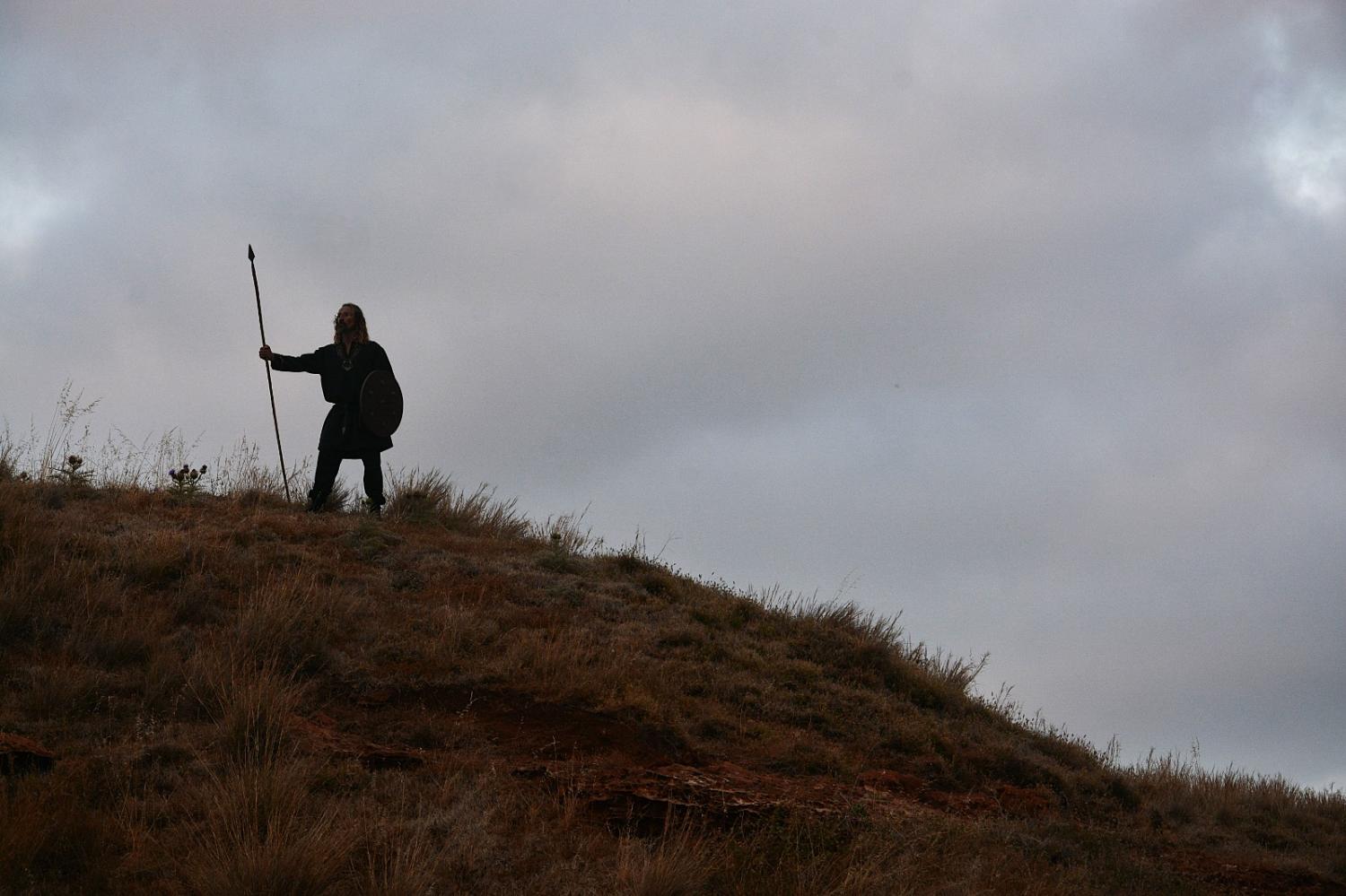 Standing on a dry hillside under storm cloud