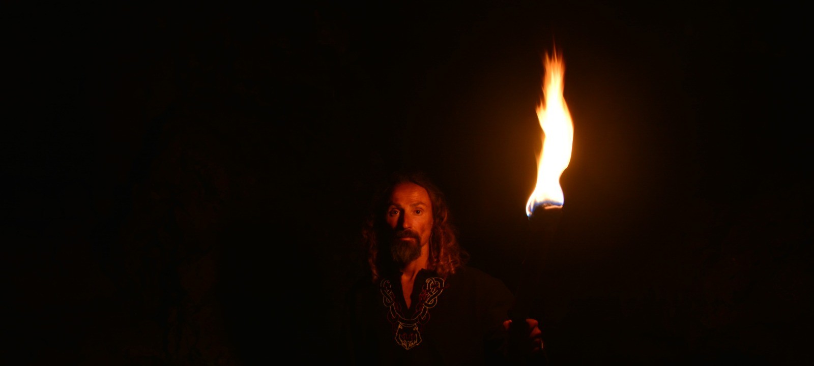 Torch-lit portrait against black