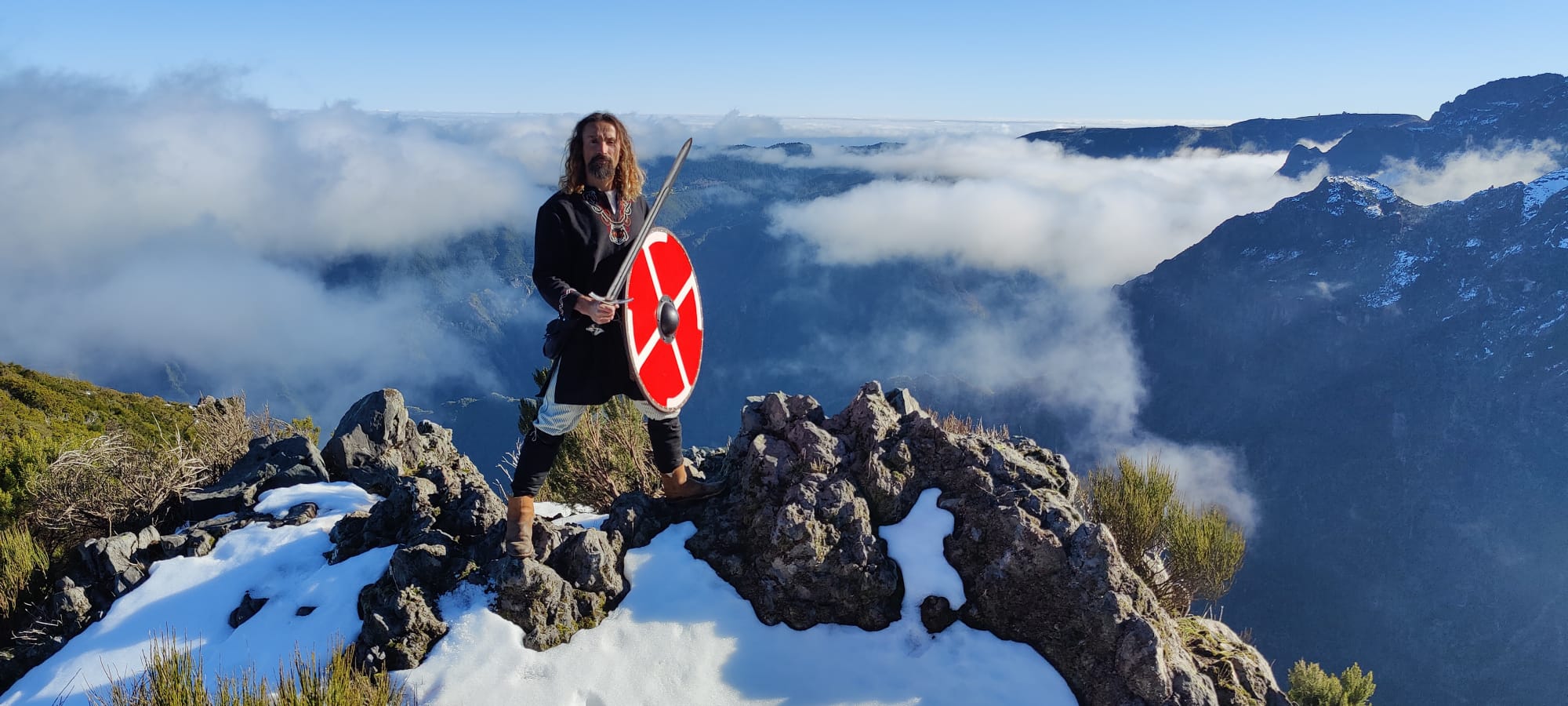 Warrior with a red shield on a snowy mountain ridge